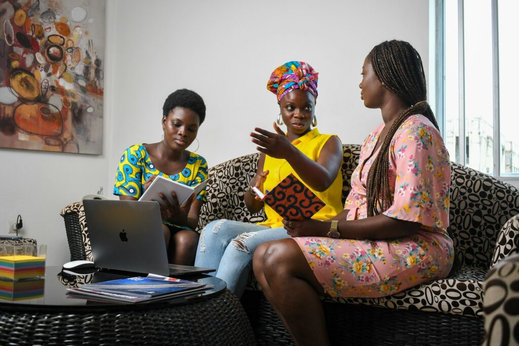 Trois jeunes femmes échangeant autour d’un ordinateur